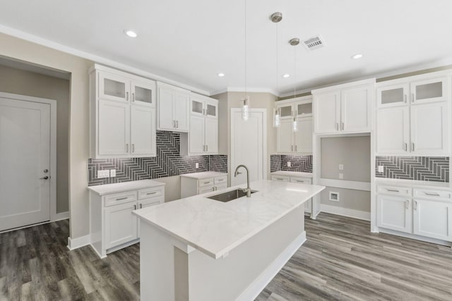 kitchen with a center island with sink, visible vents, dark wood-style flooring, and a sink