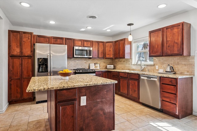 kitchen with stainless steel appliances, visible vents, decorative backsplash, a sink, and light stone countertops