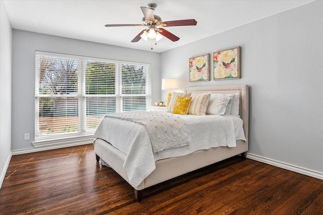 bedroom with ceiling fan, wood finished floors, and baseboards