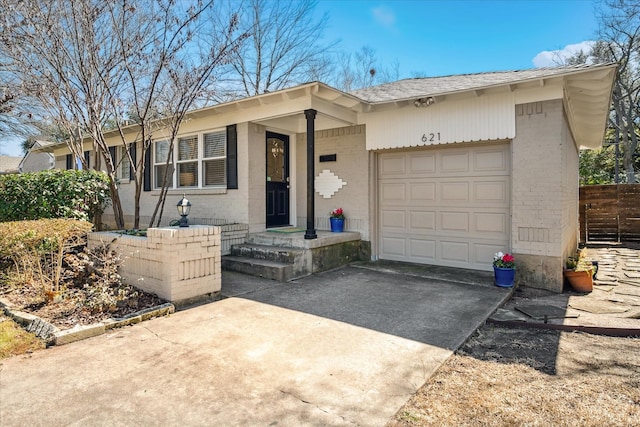 single story home featuring brick siding, driveway, and an attached garage