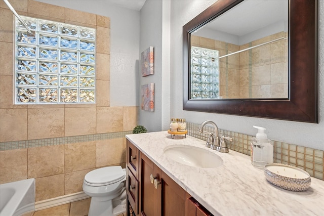 bathroom featuring tile patterned flooring, a bathing tub, toilet, vanity, and walk in shower