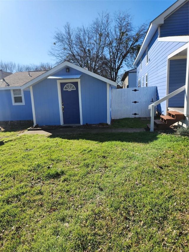 exterior space featuring fence, a storage unit, and an outbuilding