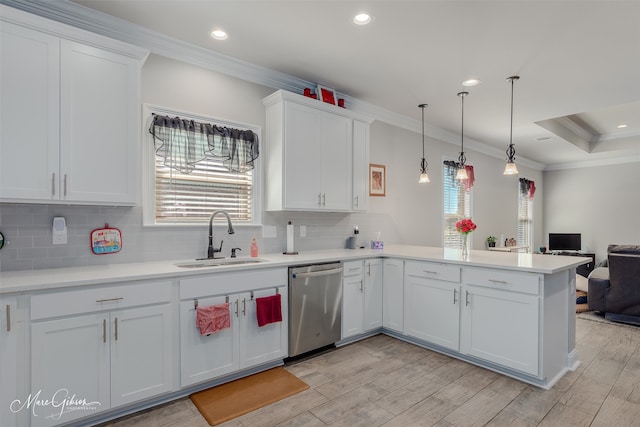 kitchen featuring ornamental molding, open floor plan, a sink, dishwasher, and a peninsula