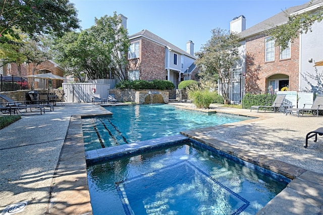 pool featuring a patio area, fence, and a hot tub