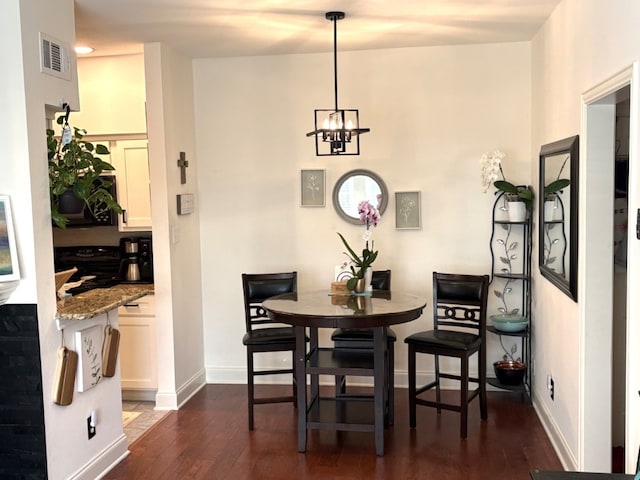 dining area featuring visible vents, dark wood finished floors, baseboards, and an inviting chandelier