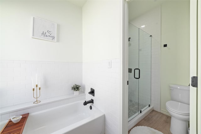 bathroom with toilet, a stall shower, a bath, and wood finished floors