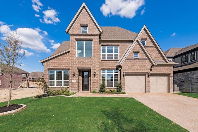 1628 Rimini Rd, Fate, TX 75087 - view of front of home with roof with shingles, a front yard, a garage, brick siding, and concrete driveway
