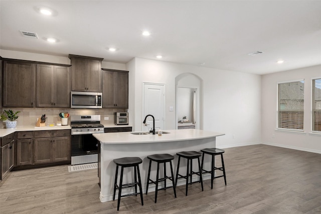 kitchen with appliances with stainless steel finishes, a sink, visible vents, and decorative backsplash