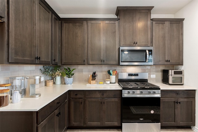 kitchen with stainless steel appliances, dark brown cabinets, backsplash, and light countertops