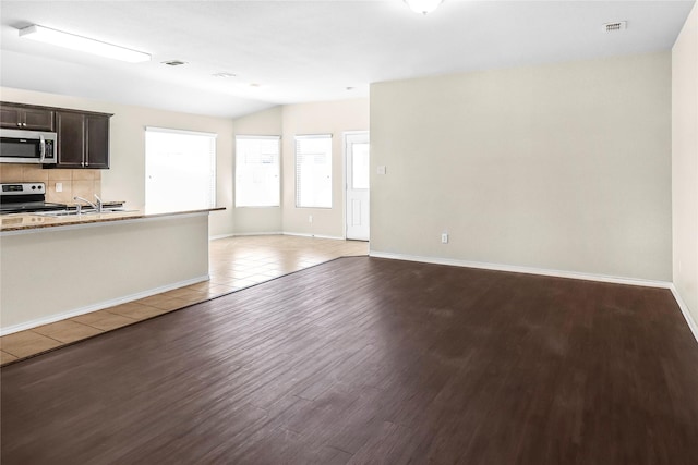 302 Triple Crown Ln, Ponder, TX 76259 - unfurnished living room featuring visible vents, a sink, baseboards, and wood finished floors