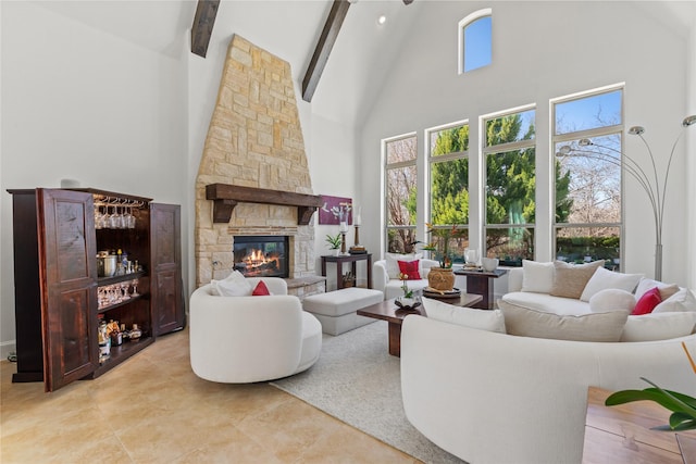 living area with high vaulted ceiling, beam ceiling, a stone fireplace, and light tile patterned floors