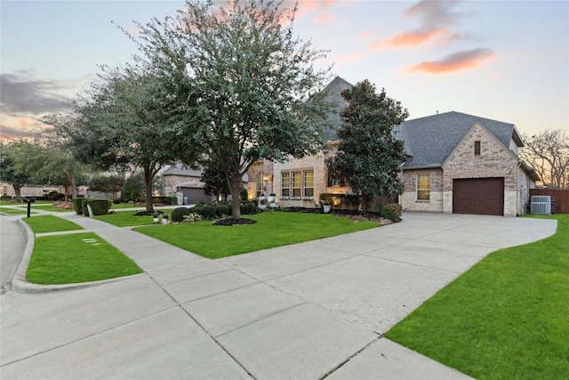 view of front facade featuring central AC unit, concrete driveway, stone siding, roof with shingles, and a front lawn