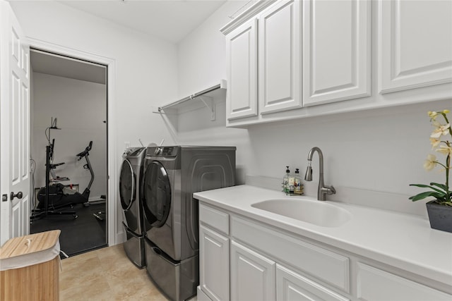 laundry area with separate washer and dryer, a sink, and cabinet space