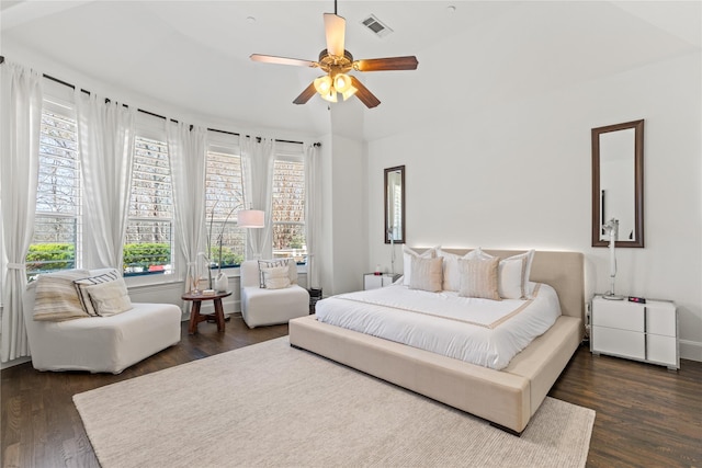 bedroom featuring dark wood finished floors, visible vents, and a ceiling fan