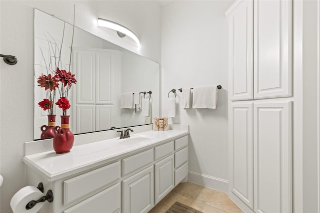 bathroom with vanity, baseboards, and tile patterned floors