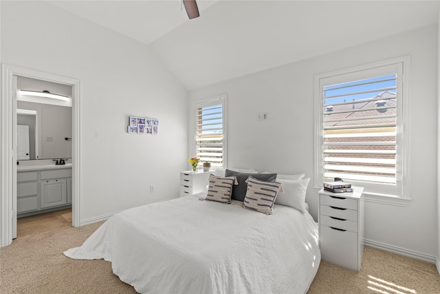 bedroom featuring light carpet, ensuite bath, multiple windows, and lofted ceiling