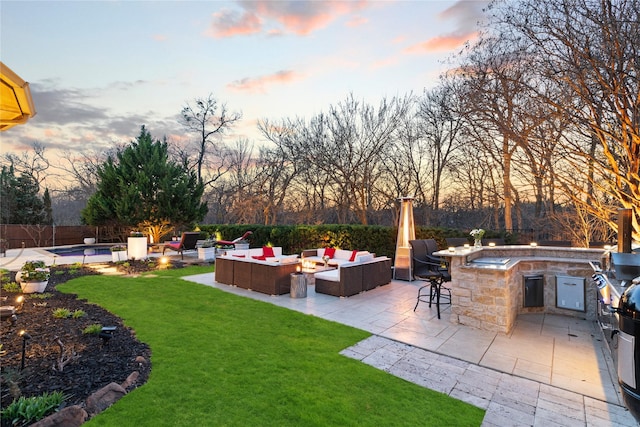 view of yard featuring an outdoor living space with a fire pit, outdoor dry bar, fence, exterior kitchen, and a patio area