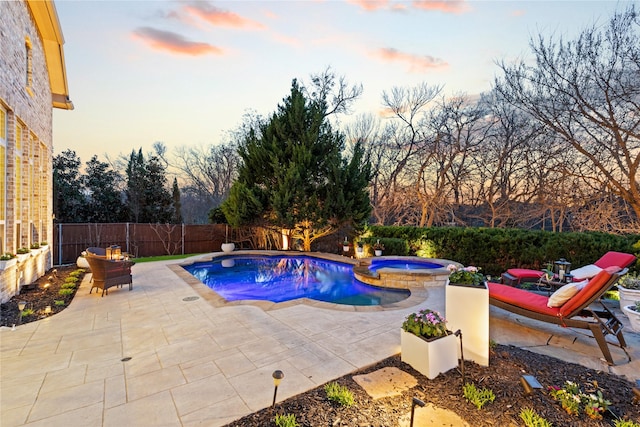 view of swimming pool with a fenced backyard, a pool with connected hot tub, and a patio