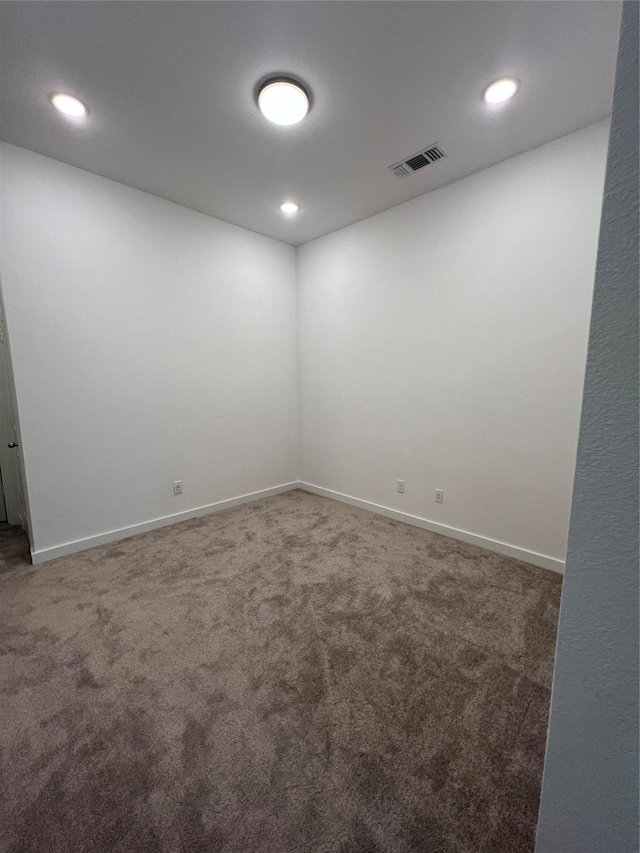 spare room with recessed lighting, carpet flooring, visible vents, and baseboards