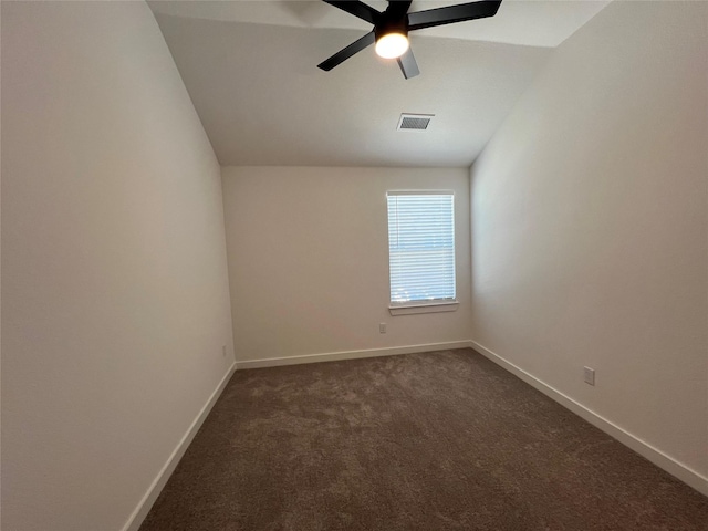 unfurnished room featuring a ceiling fan, visible vents, vaulted ceiling, baseboards, and dark colored carpet