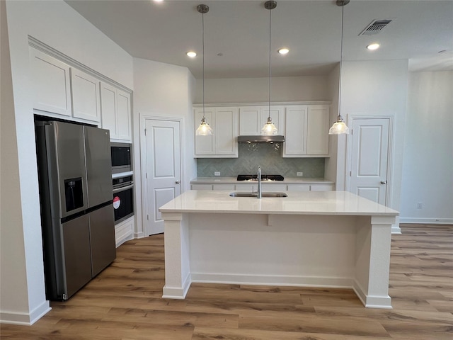 kitchen with tasteful backsplash, visible vents, appliances with stainless steel finishes, white cabinetry, and a sink