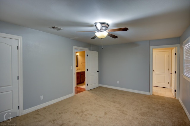 unfurnished bedroom with ensuite bathroom, carpet flooring, visible vents, and baseboards