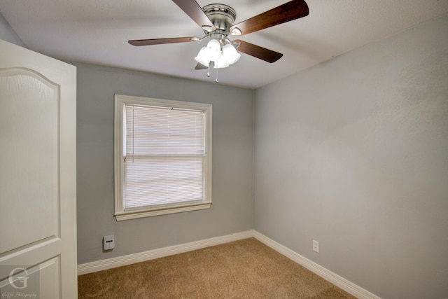 unfurnished room featuring carpet floors, a ceiling fan, and baseboards