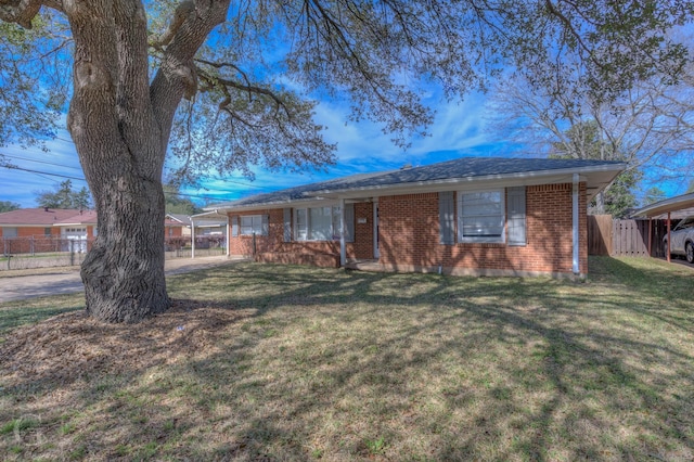 ranch-style house featuring brick siding, a front lawn, a shingled roof, and fence