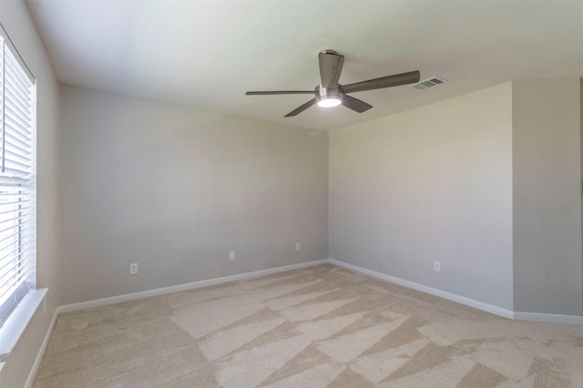 unfurnished room with light carpet, baseboards, visible vents, and a ceiling fan