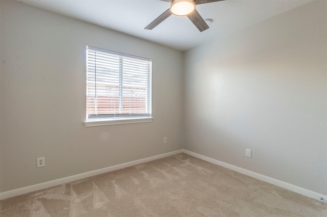 spare room featuring ceiling fan, baseboards, and light colored carpet