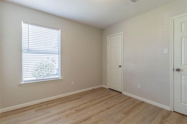 spare room featuring light wood-style flooring and baseboards