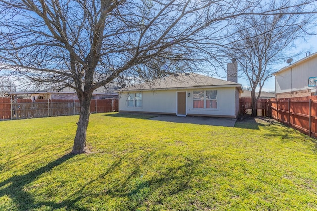 rear view of property with a fenced backyard, a lawn, and a chimney