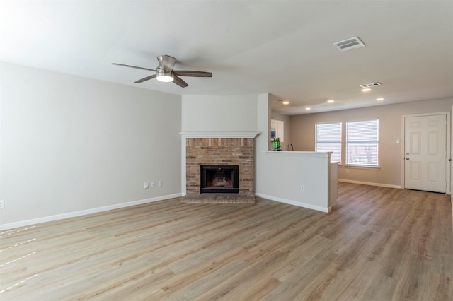 unfurnished living room featuring light wood finished floors, recessed lighting, visible vents, and baseboards