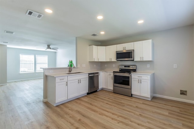 kitchen featuring stainless steel appliances, light countertops, a sink, and visible vents