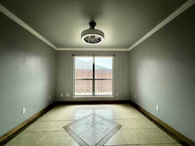 empty room with baseboards, crown molding, and light tile patterned flooring