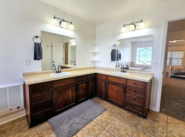 ensuite bathroom with double vanity, ensuite bath, visible vents, and a sink