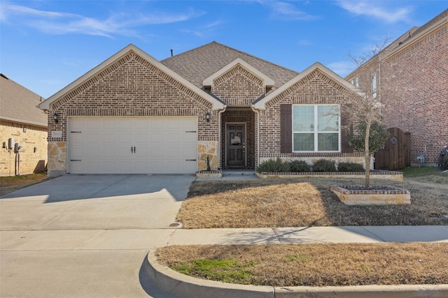 ranch-style house featuring an attached garage, brick siding, driveway, stone siding, and roof with shingles