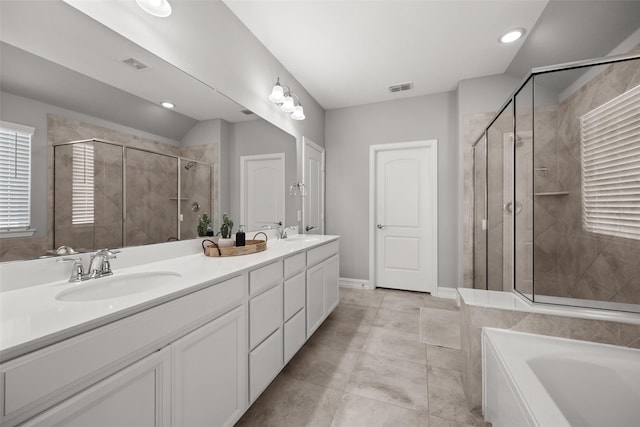 bathroom featuring double vanity, a shower stall, visible vents, and a sink