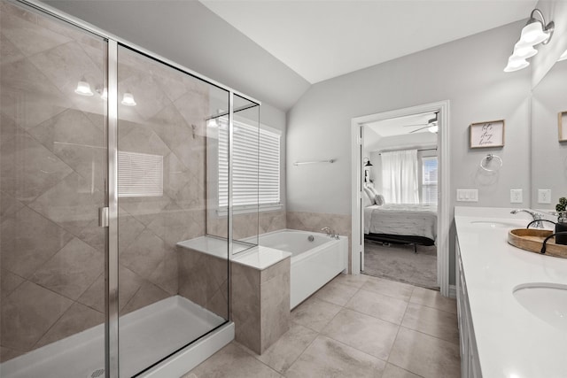 bathroom featuring ensuite bathroom, lofted ceiling, a garden tub, a shower stall, and double vanity