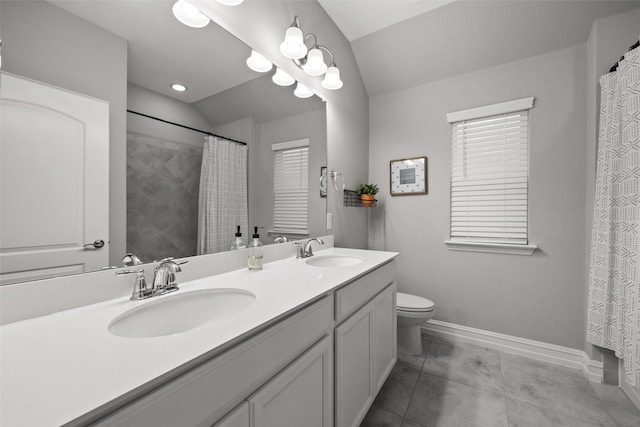 bathroom featuring toilet, a sink, baseboards, and double vanity