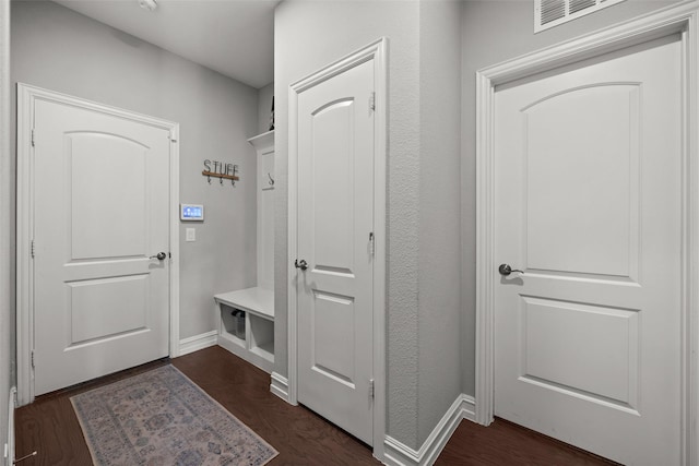 mudroom featuring dark wood-type flooring and baseboards