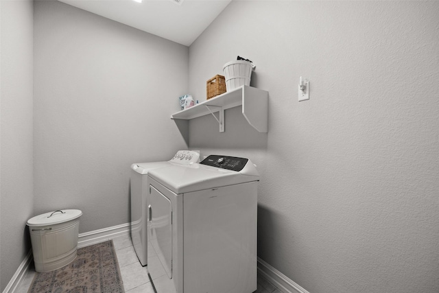 clothes washing area with laundry area, light tile patterned floors, baseboards, and separate washer and dryer