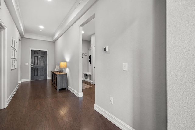 entryway with ornamental molding, dark wood-type flooring, and baseboards