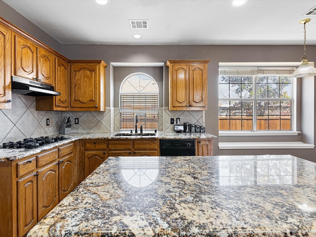 kitchen featuring visible vents, a sink, light stone countertops, under cabinet range hood, and black appliances