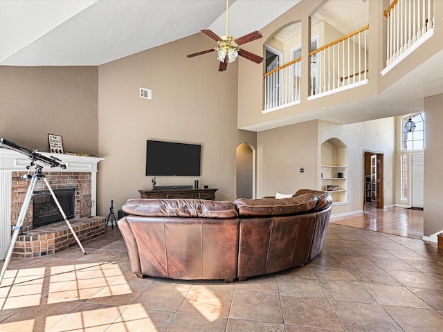 living area featuring light tile patterned floors, built in shelves, a fireplace, and visible vents