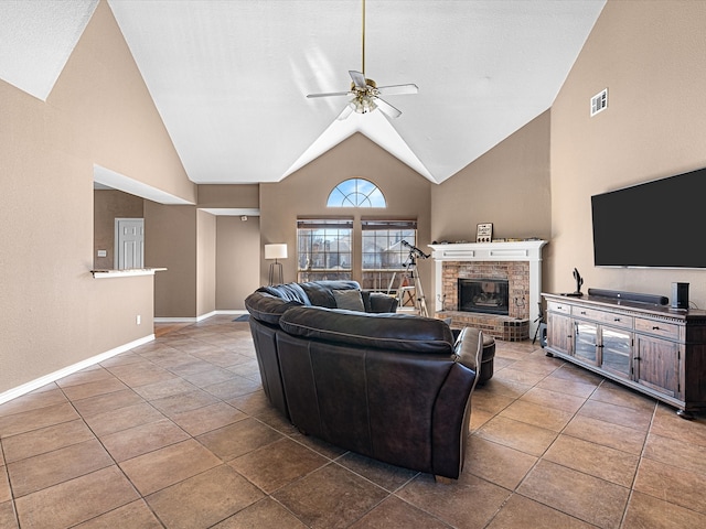 tiled living area with a fireplace, visible vents, ceiling fan, high vaulted ceiling, and baseboards