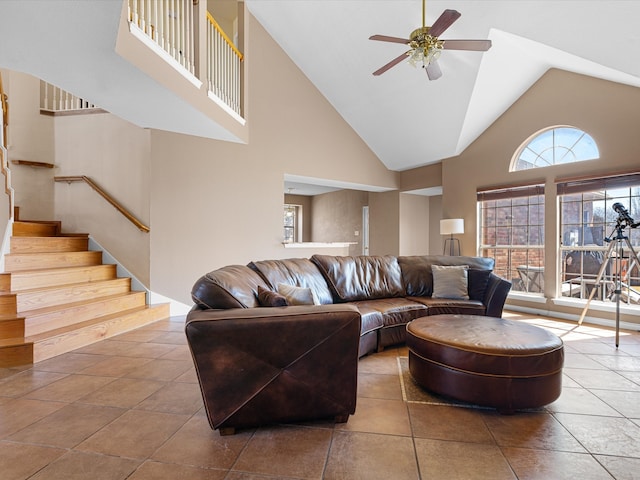 living area featuring ceiling fan, a high ceiling, stairway, and tile patterned floors