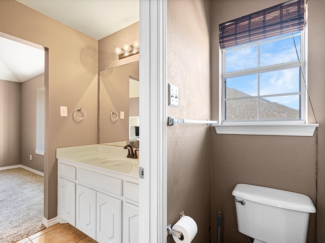 bathroom featuring baseboards, vanity, toilet, and tile patterned floors