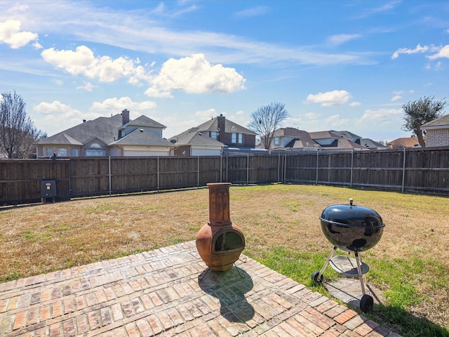 view of yard featuring a fire pit, a patio, a fenced backyard, and a residential view