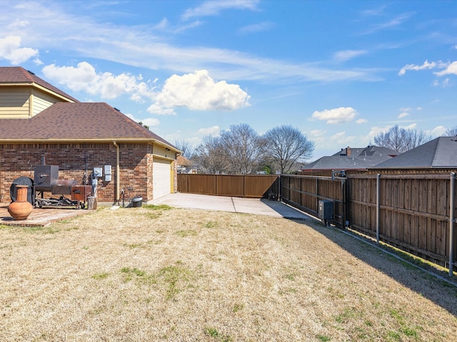 view of yard featuring a garage, a patio, and fence